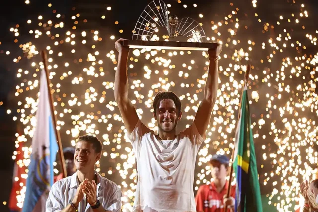 Argentino é campeão do Rio Open 2026 Tomás Etcheverry segurando o troféu de campeão do Rio Open 2026 na quadra de saibro do ATP 500 no Rio de Janeiro.