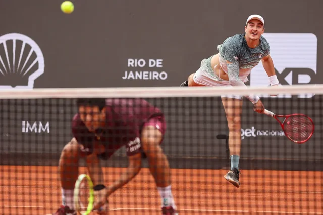 João Fonseca e Marcelo Melo vão à final de duplas do Rio Open após vitória no super tie-break João Fonseca saca e Marcelo Melo prepara smash durante jogo de duplas no Rio Open