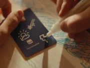 Campanha Itaú Personnalité mostra pessoa desenhando símbolos em cartão azul sobre papel, representando sonhos, projetos e conquistas financeiras.