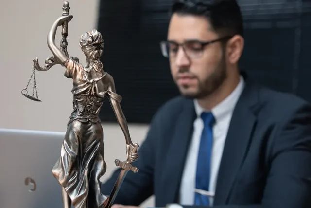 Marketing digital para pequenas empresas: o que a advocacia ensina sobre crescer dentro das regras Advogado em escritório diante de uma estátua da Justiça, representando marketing jurídico e estratégias digitais para escritórios de advocacia.
