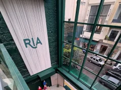 Vista interna da flagship da Riachuelo na Oscar Freire mostra o espaço de entrada, a arquitetura da loja e a movimentação da rua.
