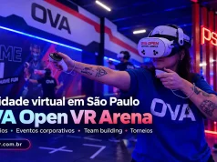 OVA Open VR Mulher usando óculos de realidade virtual na OVA Open VR Arena, em São Paulo, com área de jogos, PS Zone e outros participantes ao fundo.