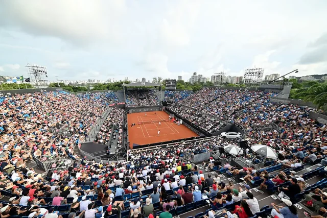 Rio Open 2027: saiba como comprar ingressos e confira os preços Vista panorâmica da quadra central de saibro do Rio Open, com arquibancadas lotadas de torcedores durante uma partida de tênis no Jockey Club Brasileiro, no Rio de Janeiro.
